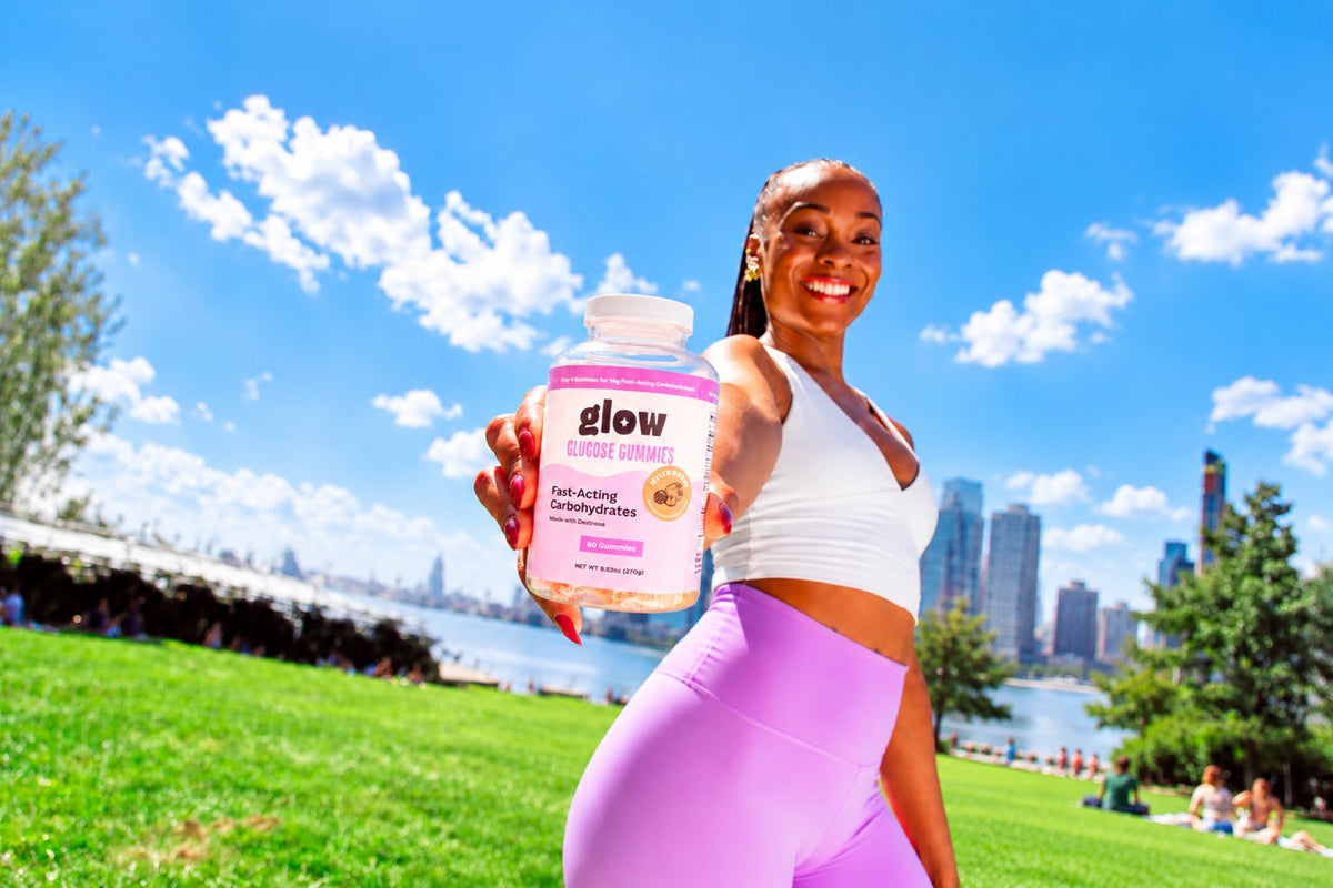 Glow Gummies by the waterfront, model holding Mixed Berry bottle